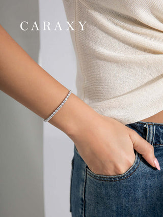 Model wearing Eclat Flow lab grown diamond C-Clasp tennis bracelet against a casual outfit.