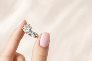 A lady holds a twisted shank engagement ring