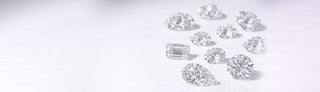 Loose diamonds of various shapes scattered on a white background