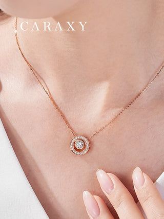 Close-up of an 18K rose gold round diamond pendant necklace worn on the neck.