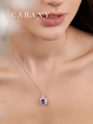18K white gold sapphire floral halo necklace worn on model, featuring a cornflower blue oval sapphire and diamond accents.