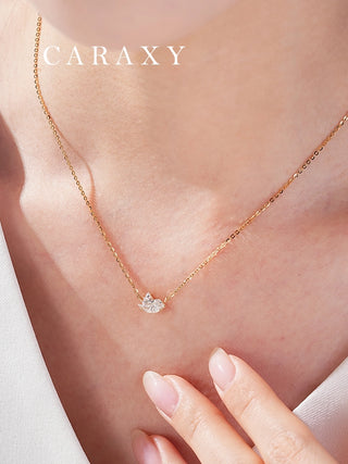 Close-up of 18K yellow gold diamond pendant necklace with delicate bird-inspired design.
