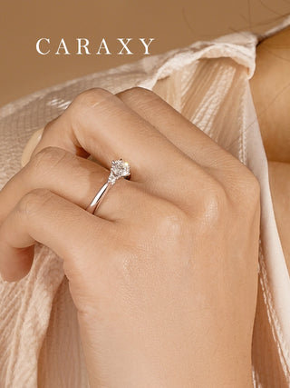 Close-up lifestyle shot of the 18k white gold three stone diamond ring on a model's hand.