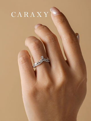 Close-up of an 18K white gold curved diamond wedding band paired with an engagement ring