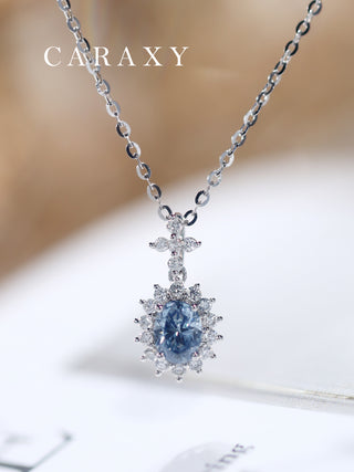 Close-up of a lab-grown blue diamond pendant necklace in 18K white gold on a surface.