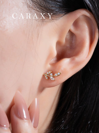 Botanical diamond earrings shown on model with elegant natural styling.