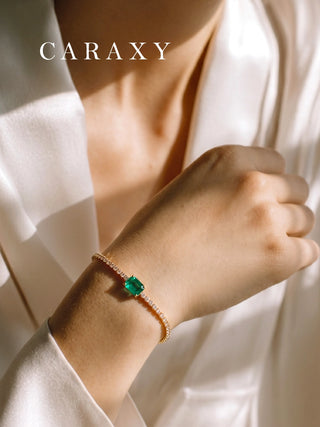 Close-up lifestyle view of an 18K yellow gold emerald and lab-grown diamond bracelet on the wrist