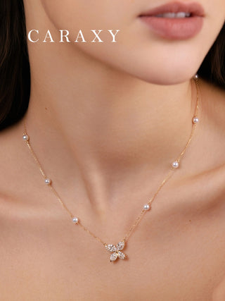 Close-up of an 18K yellow gold diamond butterfly necklace with spaced pearls