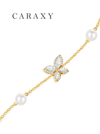 Close-up of a butterfly formed with marquise and round diamonds on a pearl station necklace