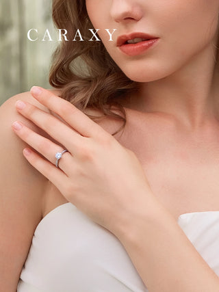 Close-up of a classic cathedral setting diamond ring on finger highlighting the tapered shank.