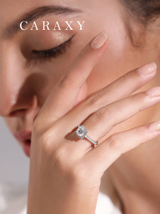 Lifestyle view of a model wearing a classic CARAXY round brilliant halo diamond ring.