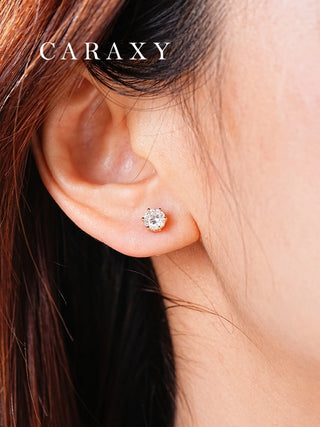 Close-up of round six-prong lab-grown diamond stud earrings worn on the ear