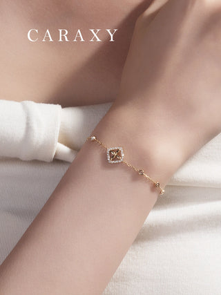 Close-up of an 18K yellow gold lab grown diamond bracelet on wrist featuring a clover-inspired motif and bezel-set station diamonds.