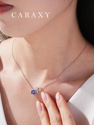 Close-up of cornflower blue lab-grown sapphire necklace with diamond bow accents on neckline