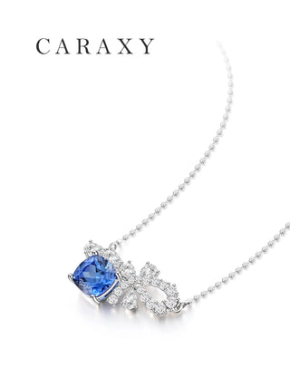 Angled view of cushion cut lab-grown blue sapphire necklace with bow-inspired diamond details
