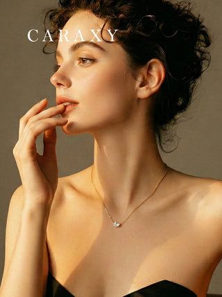 Woman wearing a dainty lab grown diamond pendant necklace in 18K yellow gold.