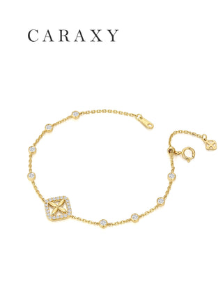 Dainty 18K yellow gold lab grown diamond bracelet featuring bezel-set station diamonds, a clover-inspired centerpiece, and adjustable slider closure.