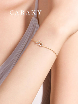 Close-up of a model wearing the dainty gold leaf branch diamond bracelet, showcasing its delicate scale on the wrist.