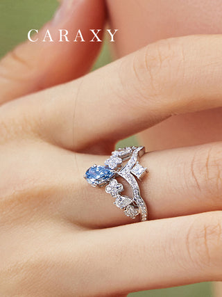 Close-up on hand showing the elegant dangling blue pear diamond on a tiara ring.