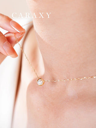 Close-up of a seed-inspired round diamond pendant necklace worn on the neck