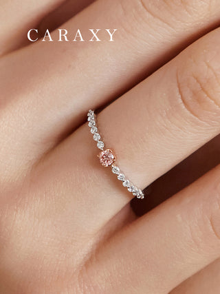 Close-up of a delicate lab grown diamond ring with a pink center stone in a two-tone setting