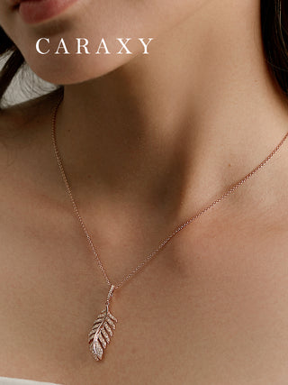Close-up of a model wearing a diamond feather pendant necklace with a refined and delicate design.