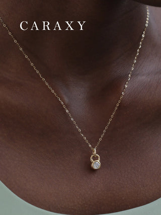 Close-up of a diamond kettlebell pendant necklace worn as everyday fitness-inspired jewelry.