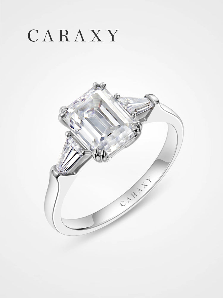 Emerald cut three-stone engagement ring with tapered baguette side stones.