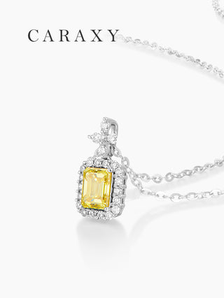 Close-up of an emerald cut fancy yellow lab grown diamond halo pendant necklace in 18K white gold.