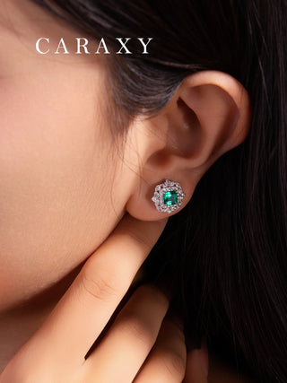 Model wearing emerald halo stud earrings with lab created emerald center stones and lab grown diamond accents.
