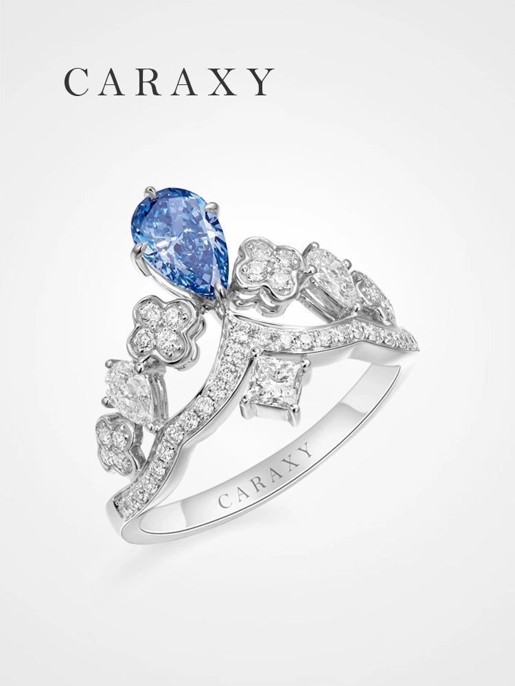 A unique fancy blue diamond tiara ring featuring a dangling pear-shaped diamond.