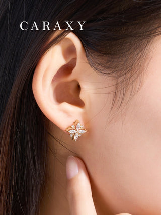 Model wearing floral diamond studs in a close-up ear view.
