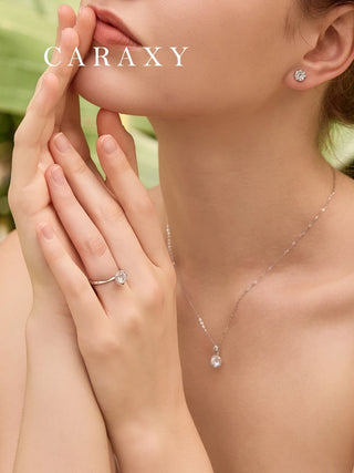 Floral halo engagement ring paired with matching necklace and earrings set.