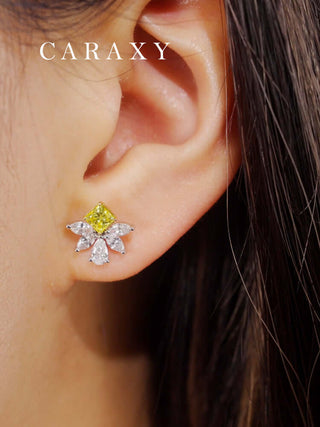 Model wearing floral yellow diamond earrings in a close-up ear view.