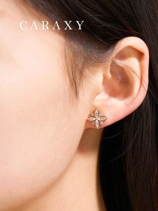 Four-petal diamond earrings shown on model with soft natural styling.