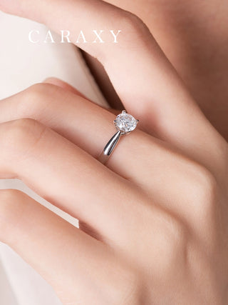 Lifestyle view of a four-prong solitaire engagement ring on finger to show diamond clarity.