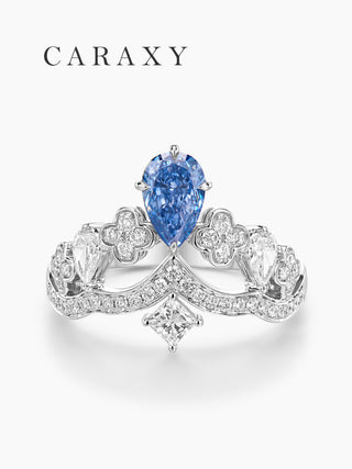 front view crown diamond ring with blue pear center stone and ornate motifs
