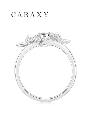 Side view of a lab created blue sapphire ring showing the raised setting and sculptural floral details.
