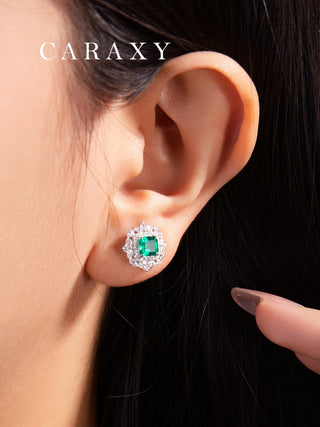 ab created emerald stud earrings worn on ear, featuring Asscher cut emeralds and sparkling diamond halo design.