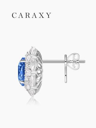 Side view of lab created sapphire halo stud earrings showing the open gallery, four-prong oval sapphire setting, and 18K white gold structure.