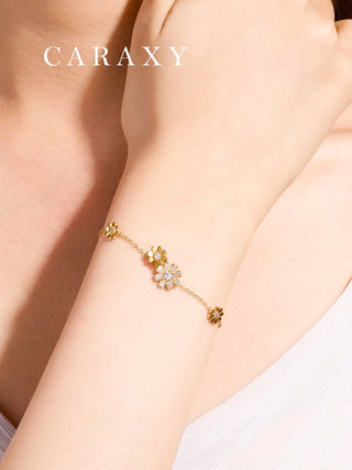 Daisy-inspired lab grown diamond bracelet in 18K yellow gold worn on the wrist, featuring delicate floral motifs and a fine cable chain.