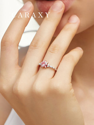 Lab-grown pink diamond engagement ring worn on the hand.