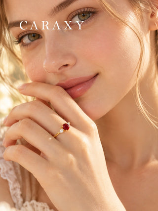 Woman wearing a lab grown ruby and pear diamond ring in 18K yellow gold