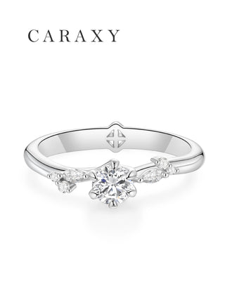 Top view of a leaf engagement ring featuring marquise side stones and a round brilliant center.