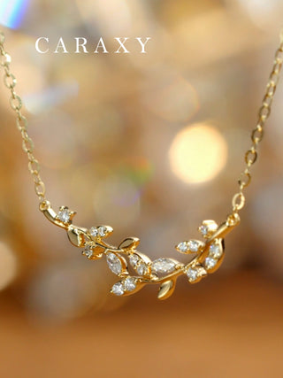 Lab grown diamond leaf vine necklace in 18K yellow gold with marquise and round diamonds, close-up lifestyle view.