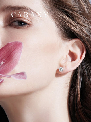 Minimal diamond earrings shown on model with soft floral styling.