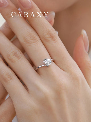 Close-up on finger showing the flowing lines of a nature-inspired engagement ring.