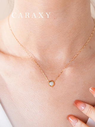 Model wearing a delicate seed-inspired lab-grown diamond necklace in yellow gold