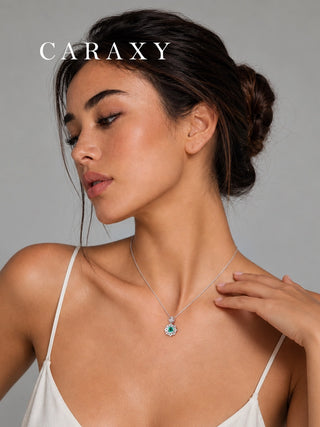 Woman wearing a emerald gemstone and diamond pendant necklace in 18K white gold