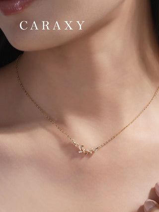 Nature-inspired leaf vine diamond necklace in 18K yellow gold shown worn on the neck.